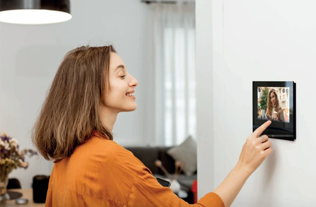 Woman answering a 2N indoor unit with a touchscreen